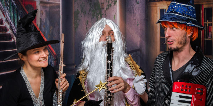 Zwei verkleidete Musiker und eine Musikerin mit ihren Instrumenten